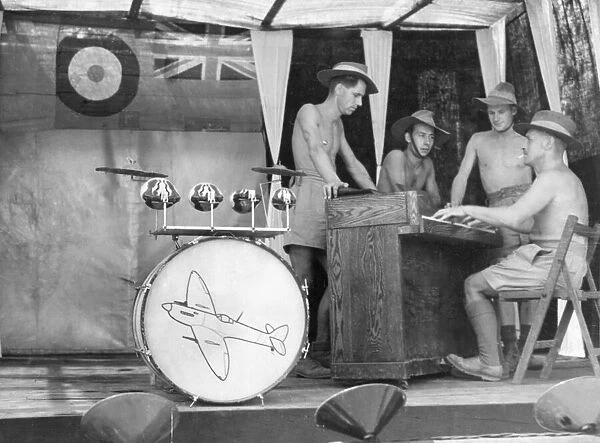 Men of the Royal Air Force spend their lunch time break with a song at the piano in their