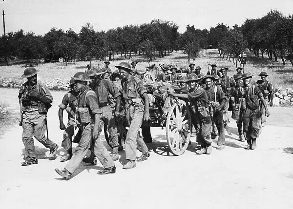 Men of the Seaforth Highlanders pushing forward with equipment in the Rosolini-Noto area