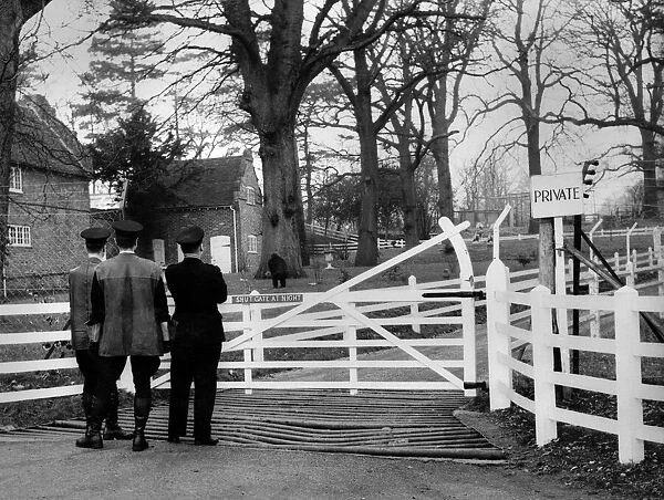 Three men standing at the gateway entrance to the animal park owned by millionaire John