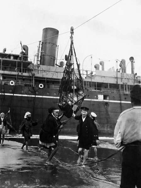Men taking baggage off a ship. Circa December 1911