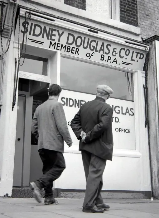 Framed Print : Two men walking past Sidney Douglas betting shop in Mile End Road London May 1961