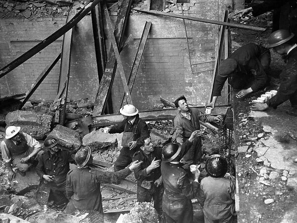 Men working in a building damaged by an Air Raid during the Blitz