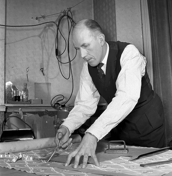 Mens Fashions: Tailor measuring and sewing in his workshop