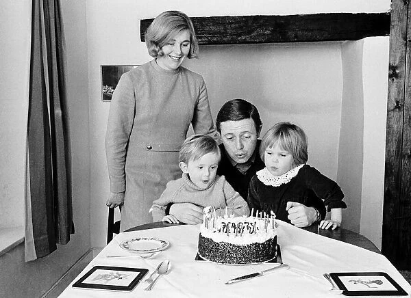 Michael Aspel tv presenter with his family blowing out birthday cake candles