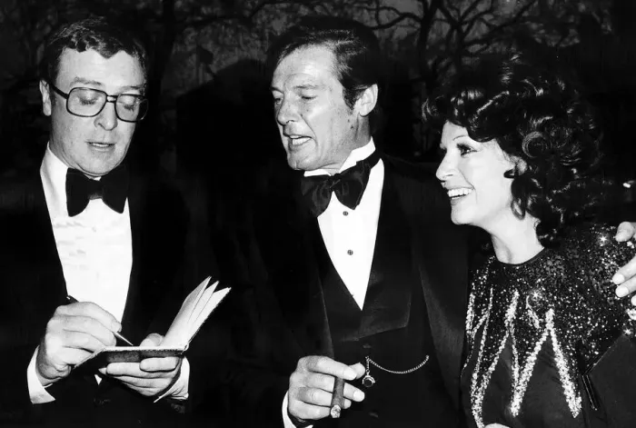 Framed Print : Michael Caine and Roger Moore - April 1976 Michael Caine actor attends