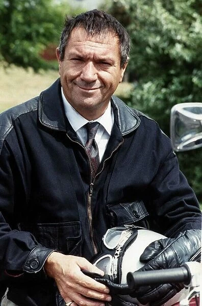 Michael Elphick sitting on motorcycle holding crash helmet