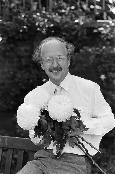 Michael Fish, BBC Weather man, pictured with a new strain of Chrysanthemum Flower that