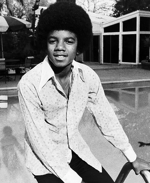 Michael Jackson Singer sitting on the edge of swimming pool circa 1975