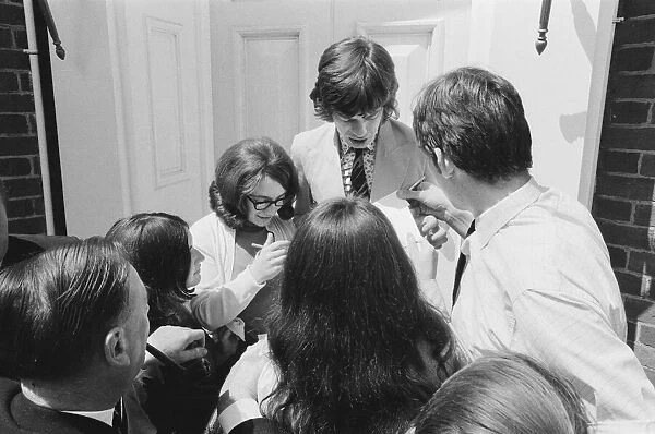 Mick jagger, lead singer of the Rolling Stones pop group is surrounded by autograph