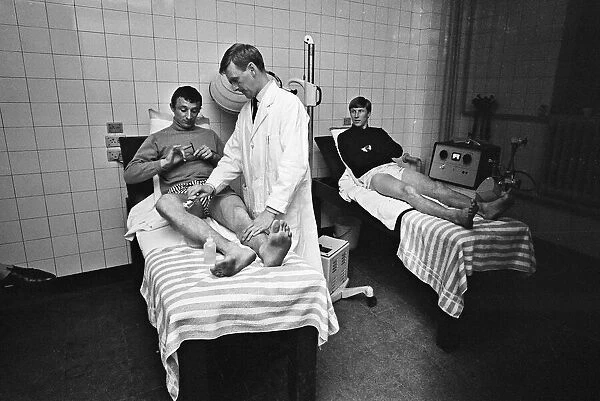 Mike Summerbee (left) being examined Manchester City players Colin Bell