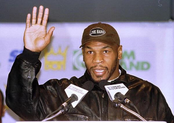 Mike Tyson waves during the head to head press Conference for the Heavyweight World Title