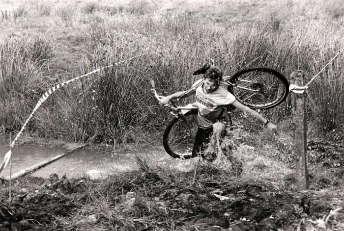 Framed Print : Mind how you go... a competitor carries his cycle across one of the many bogs negotiated