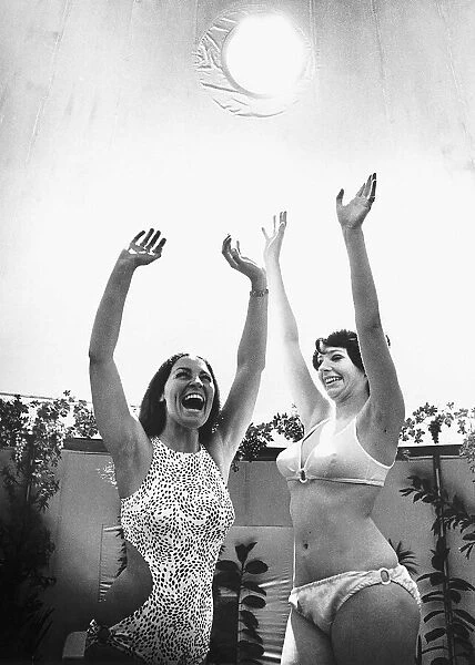 Miss Great Britain (L) and Actress Trix Pelham revel in the artifical sunshine of