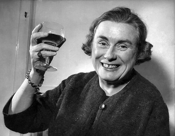 Miss. Gwen Robyns raises a glass of wine. December 1960