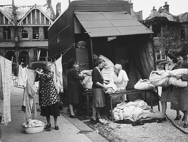 A mobile laundry service working from the back of a lorry accepts more washing during WW2