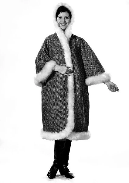 Model Ann Cave shows off a cape coat complete with hood made in gray