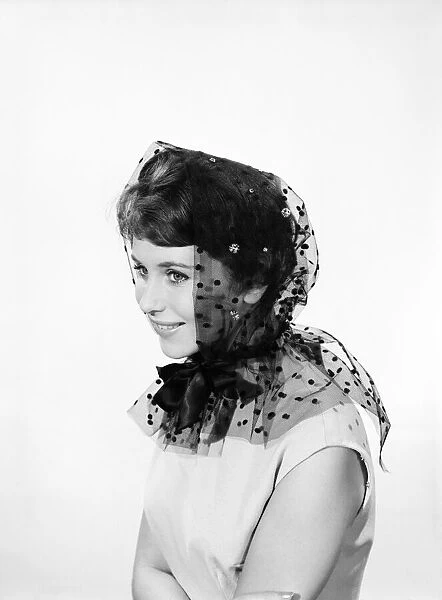Model Ann Cave wearing a collection of spring and summer hats. Circa 1962