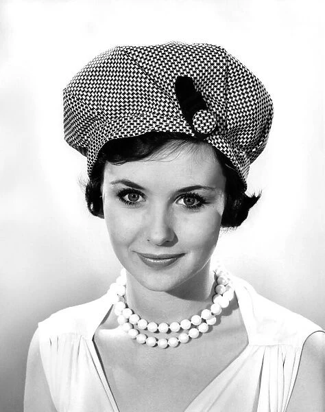 Model Ann Cave wearing a patterned stylish hat with pearl necklace