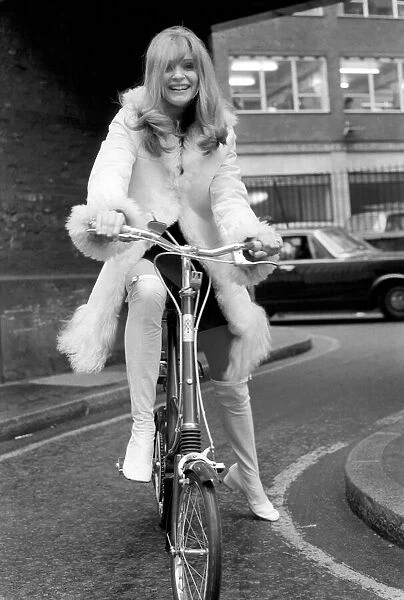 Model Blanche Webb wearing a fur jacket, riding a bicycle. November 1969 Z11350-006