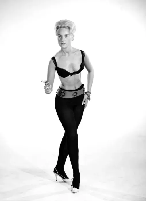 Framed Print : Model Brenda Bartlet dressed as Bond girl holding gun. October 1959