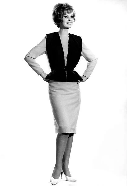 Model Dawn Chapman wearing waistcoat with pencil skirt, standing with hands on hips