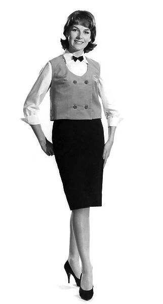 Model Diana Lovell wearing shirt bow tie and waistcoat with knee length skirt