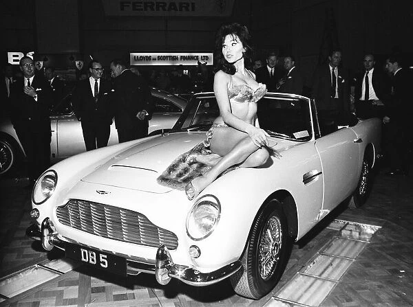 Model drapped over the bonnet of an Aston Martin DB5 at the British International Motor