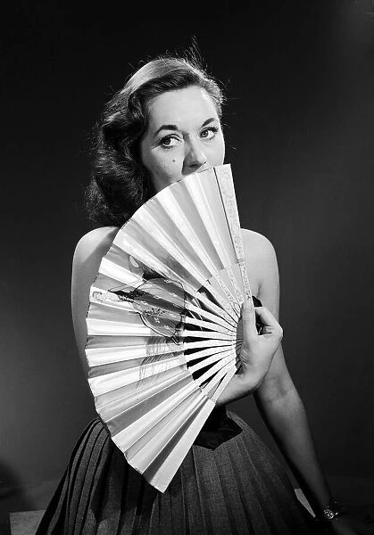 Model with fan in strapless dress. Model with fan in strapless dress. Circa 1964