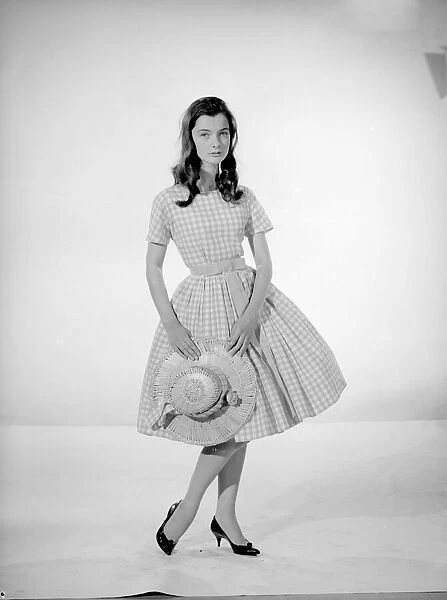 Model Jennifer Goddard. Brown-haired girl in checkered dress with hat