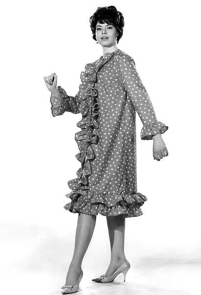 Model Jennifer White wearing a knee length spotty dress with frills