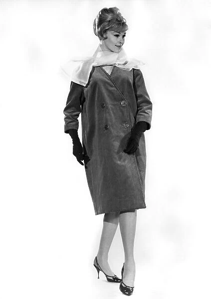 Model Jo Waring wearing a three quarter length buttoned coat with full length gloves