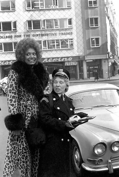 Model Lorne Lesley wearing a long leopard skin coat with fur collar standing behind a