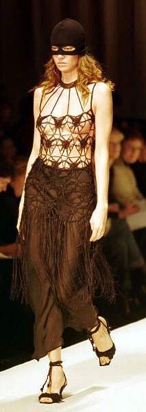 A model models a crochet top and ski mask March 1999 at the Moschino fashion show
