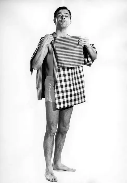 Framed Print : Model Peter Anthony wearing a smock top holding his folded clothes and tea towels Framed Print : Model Peter Anthony wearing a smock top holding his folded clothes and tea towels