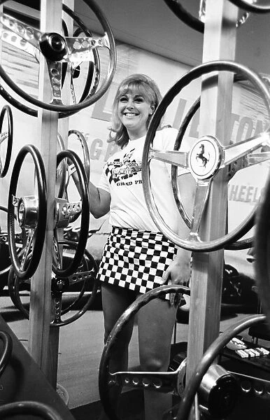 Model poses with steering wheels on a stand at the 1966 London Motor Show 18th October