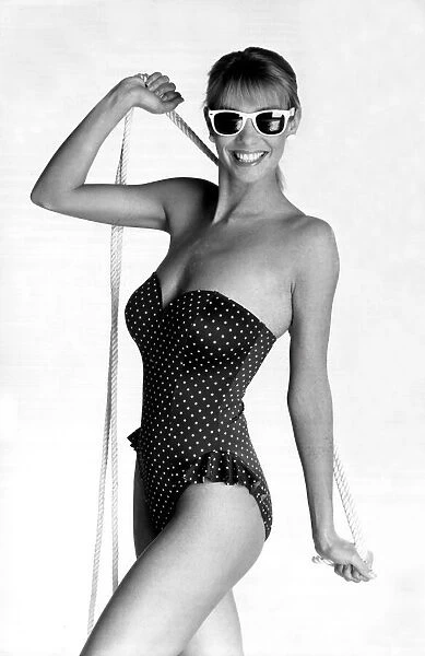 Model posing in a navy and white polkadot strapless swimsuit from Marks and Spencers (17