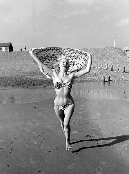 A model wearing a bikini as she enjoys the sun on the beach at Hove March 1959