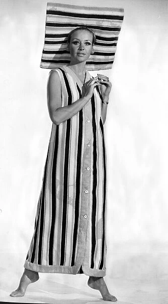 A model wearing six buttoned sleveless coat with a matching sun brim hat made in striped