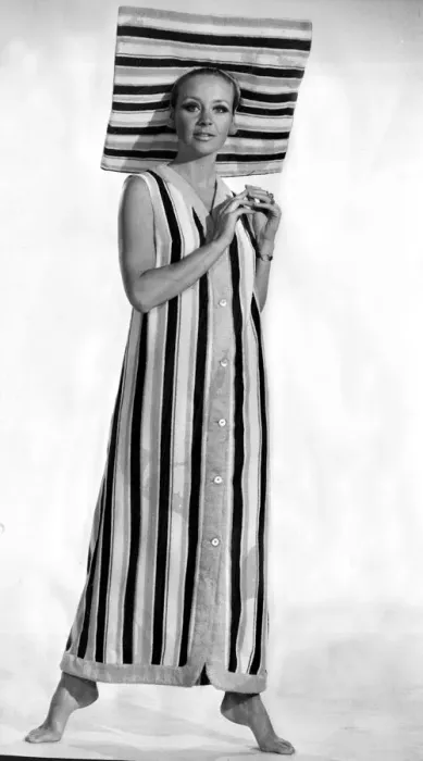 Framed Print : A model wearing six buttoned sleveless coat with a matching sun brim hat made in striped Framed Print : A model wearing six buttoned sleveless coat with a matching sun brim hat made in striped