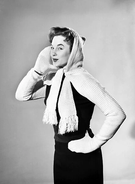 Model wearing combined hooded scarf and gloves. 1955