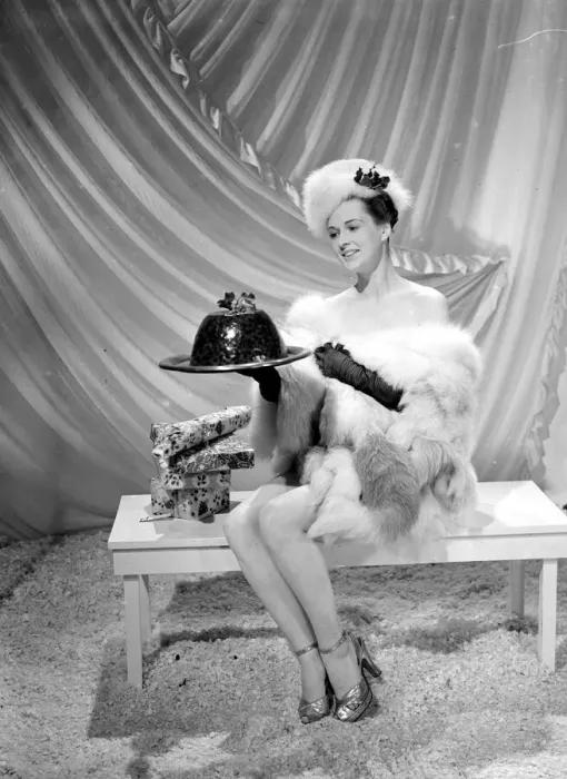Framed Print : A model wearing fur hat wrap and glove holding a christmas pudding