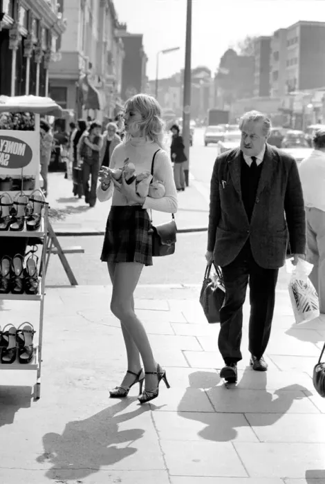 Framed Print : A model wearing a polo neck long sleeved top with tartan skirt shopping for shoes Framed Print : A model wearing a polo neck long sleeved top with tartan skirt shopping for shoes