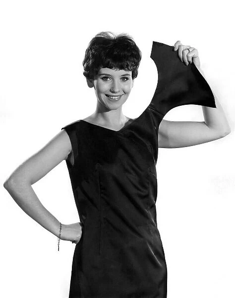 Model wearing a sleeveless black dress showing off one of the shoulder straps