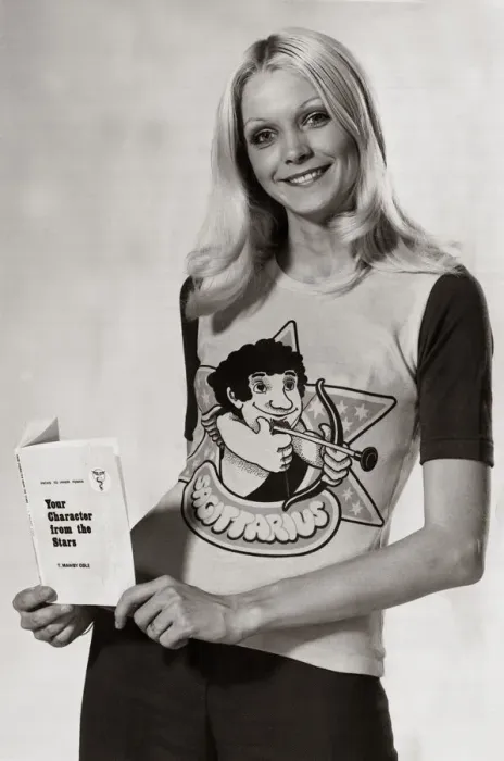 Framed Print : Model wearing a zodiac sign t-shirt witha cartoon of Sagittarius on it holding a book