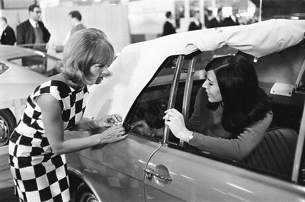 Models demonstrate the ease of lowering a soft top roof at the 1966 London Motor Show