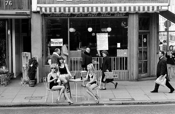 Models wearing swimsuits sit outside Guys and Dolls in the Kings Road Chelsea London