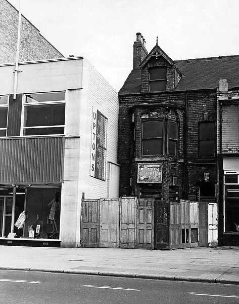 Next to a modern shop front next to a boarded up house, Linthorpe Road. 16th June 1966