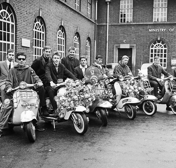 Mods wearing suits and parkas on Motor Scooters covered with extra lights