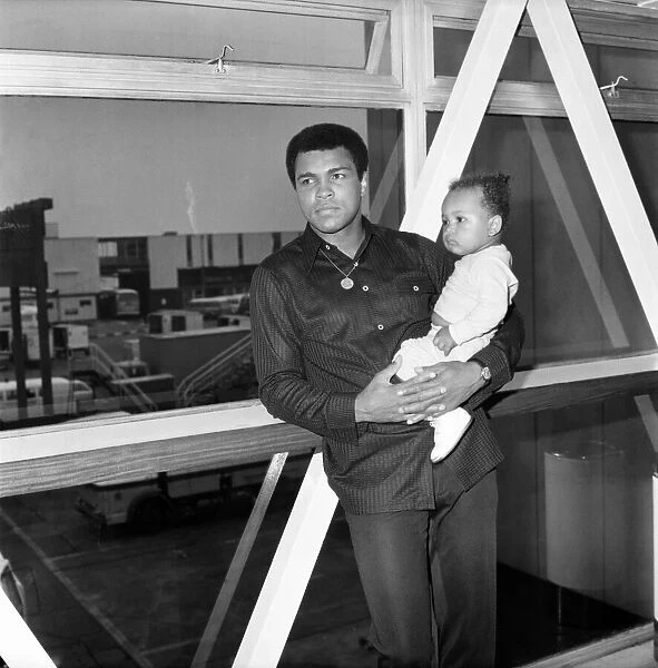 Mohammad Ali with baby Hanna at Heathrow Airport today. August 1977 77-04380-003