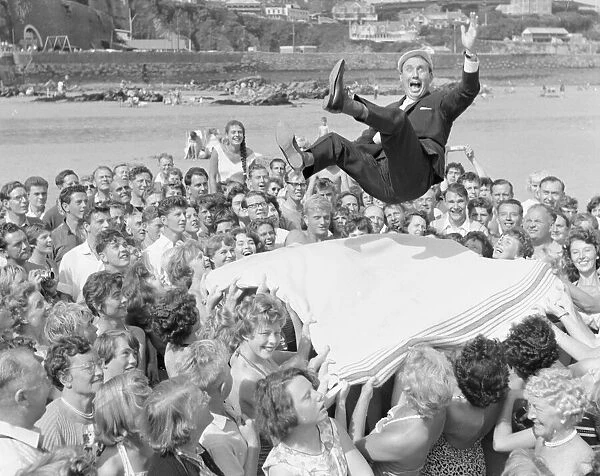 Monroe competition at Newquay. Crowds hold out a large blanket to catch a man
